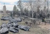  ?? ?? Bodies of civilians are moved to the cemetery in Bucha, left, while below, a rescue worker outside an apartment building destroyed by shelling in Borodianka, Ukraine