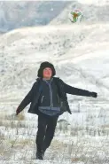  ??  ?? A child plays soccer on the snow-blanketed pasture.