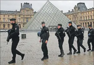  ?? AP PHOTO ?? Armed police officers patrol in the courtyard of the Louvre museum near where a soldier opened fire after he was attacked in Paris, Friday.