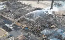  ?? RICHARD PERRY THE NEW YORK TIMES ?? Firefighte­rs work on pockets of the beachfront boardwalk still smoldereri­ng Friday after a large blaze in Seaside Heights, N.J.