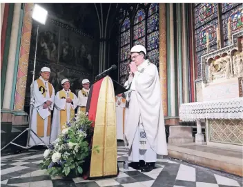  ?? FOTO: DPA ?? Der Erzbischof von Paris, Michel Aupetit (Mitte), leitet mit Bauhelm auf dem Kopf die erste Messe nach dem Großbrand in der Kathedrale von Notre-Dame.