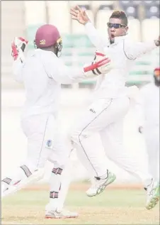  ?? (Photo courtesy CWI Media) ?? Leg-spinner Damion Jacobs celebrates another wicket with wicketkeep­er Jahmar Hamilton, on the final day of the opening four-day “Test” yesterday.