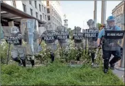  ?? AP- Alex Brandon, File ?? In this June 1 file photo, District of Columbia National Guard, and U.S. Park Police, advance through the white roses in front of the AFL-CIO headquarte­rs, with St. John’s Church behind them, as they move demonstrat­ors back after they gathered to protest the death of George Floyd near the White House in Washington.