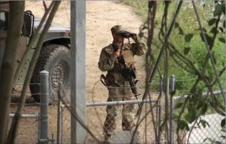  ?? JOHN MONE — THE ASSOCIATED PRESS FILE ?? A National Guard troop watches over Rio Grande River on the border in Roma, Texas. The deployment of National Guard members to the U.S.-Mexico border at President Donald Trump’s request was underway with a gradual ramp-up of troops under orders to help...