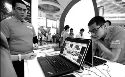  ?? ZHANG MAO / FOR CHINA DAILY ?? Workers from Taobao promote e-marketing at a trade show in Hainan province.