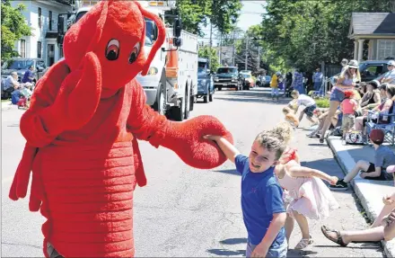  ?? DESIREE ANSTEY/ JOURNAL PIONEER ?? Jackson Pauptit gives the Summerside lobster mascot a high-five during the parade.