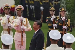  ?? ANDY WONG — THE ASSOCIATED PRESS ?? Chinese President Xi Jinping, center, walks past a guard of honor while visiting the Monument to the People’s Heroes during a ceremony to mark Martyr’s Day at Tiananmen Square in Beijing, Thursday.