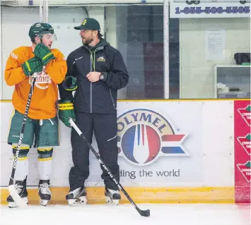  ?? KAYLE NEIS /THE CANADIAN PRESS ?? Humboldt Broncos bus crash survivor Derek Patter talks to head coach Nathan Oystrick during the first day of the Broncos training camp at Elgar Petersen Arena on Friday.