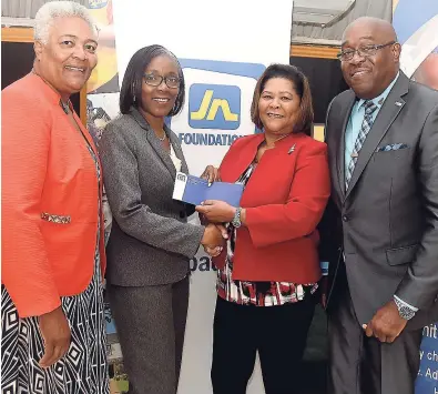  ??  ?? Rose Miller (second left), grants manager at JN Foundation, presents Dr Marcia Forbes (second right), incoming chair of the United Way of Jamaica, with a cheque to assist with disaster-relief rehabilita­tion for the Caribbean islands affected by the...