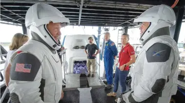  ?? NASA FILE PHOTO/BILL INGALLS ?? NASA astronauts Doug Hurley, left, and Bob Behnken work with teams from NASA and SpaceX to rehearse crew extraction from SpaceX’s Crew Dragon, which will be used to carry humans to the Internatio­nal Space Station, at the Trident Basin in Cape Canaveral, Fla. For the first time in nearly a decade, astronauts are about to blast into orbit aboard an American rocket from American soil. And for the first time in the history of human spacefligh­t, a private company — SpaceX — is providing the ride.