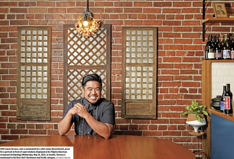  ?? AP/LINDSEY WASSON ?? CHEF Aaron Verzosa, who is nominated for a 2023 James Beard Award, poses for a portrait in front of capiz windows displayed at his Filipino American restaurant Archipelag­o Wednesday, May 24, 2023, in Seattle. Verzosa is nominated in the Best Chef: Northwest and Pacific category.