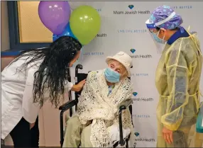  ?? (AP/Lynne Sladky) ?? Registered nurses Erika Lopez (left) and Cynthia Banada talk with Luz Collazo, 103, before she is inoculated Monday with the Moderna covid-19 vaccine at Miami Jewish Health, a senior health care facility. Collazo was alive during the Spanish flu pandemic in 1918.