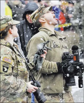  ?? KRZYSZTOF ZATYCKI/THE ASSOCIATED PRESS ?? A U.S. Army soldier plays with falling snow Saturday during the official welcoming ceremony of U.S. troops in Zagan, Poland. The ceremony marks the first time any Western forces are being deployed on a continuous basis to NATO’s eastern flank.