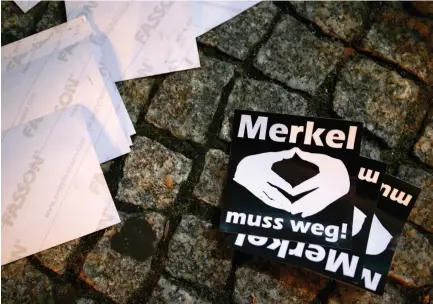  ??  ?? STICKERS WITH the words ‘Merkel must go’ lie on the pavement during a protest in Berlin.