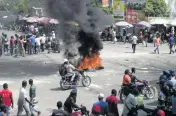  ?? ODELYN JOSEPH AP ?? People ride and walk around burning tires set up by taxi drivers to protest the country’s fuel shortage in Port-au-Prince, Haiti, on Wednesday.