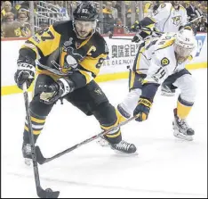  ??  ?? Pittsburgh’s Sidney Crosby controls the puck against Mattias Ekholm of Nashville during the second period of Thursday night’s rout.