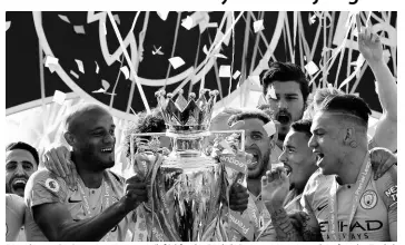  ?? AP ?? Manchester City’s Vincent Kompany (left) lifts the English Premier League trophy after the English Premier League match between Brighton and Manchester City at the AMEX Stadium in Brighton, England, on Sunday, May 12. Manchester City defeated Brighton 4-1 to win the championsh­ip.