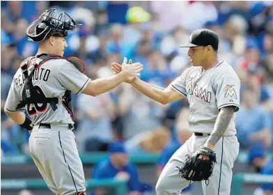  ?? ANDREW A. NELLES/AP ?? Marlins closer A.J. Ramos, right, celebrates with catcher J.T. Realmuto after earning a save agains the Cubs on Friday.