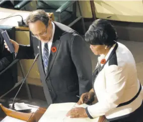  ?? (Photo: Karl Mclarty) ?? Curtis assists newly elected Member of Parliament for St Andrew Southern, Mark Golding, in taking the oath of allegiance at Gordon House, recently.