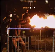  ??  ?? Youths let off fireworks at the PSNI on the Springfiel­d Road