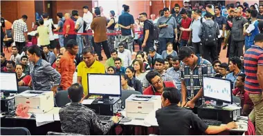  ?? — Bernama ?? Last-minute rush: Employers and foreign workers crowding the Immigratio­n department in Putrajaya to apply for the E-Cards as the deadline nears.