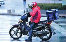  ?? YU FANGPING / FOR CHINA DAILY ?? A food delivery man in Qingdao, Shandong province, checks his orders.