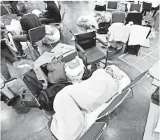  ??  ?? Yuth Chhut, 98, sleeps at the convention center, which has been packed well beyond its intended capacity.