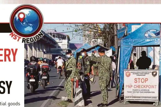  ?? EPA PIC ?? Police officers keeping watch at a checkpoint set up to prevent non-essential travel by citizens at the boundary of Rizal province and Marikina City, Metro Manila.