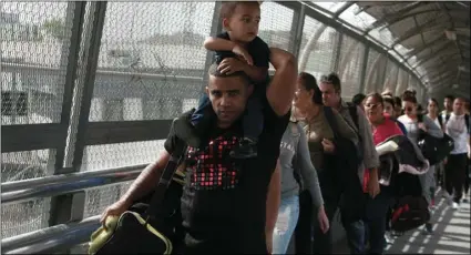  ?? AP PHOTO/CHRISTIAN TORRES ?? In this April 29 photo, Cuban migrants are escorted by Mexican immigratio­n officials in Ciudad Juarez, Mexico, as they cross the Paso del Norte Internatio­nal bridge to be processed as asylum seekers on the U.S. side of the border.