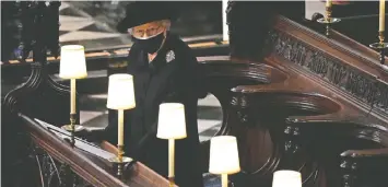  ?? YUI MOK-WPA POOL/GETTY IMAGES ?? The Queen watches the coffin of her husband of 73 years pass by her stall in the quire of St. George's chapel at Windsor Castle.