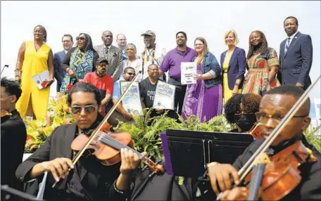  ?? CHRISTINA HOUSE Los Angeles Times ?? THE INNER City Youth Orchestra performs as state and county officials gather at Bruce’s Beach on Wednesday to present the deed to the Bruce family. “These aren’t moments, they are movements,” said Supervisor Holly Mitchell. “This has been a marathon, not a sprint.”