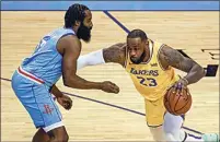  ?? TROY TAORMINA / POOL VIA AP ?? Lakers forward LeBron James (23) drives past Rockets guard James Harden during the first quarter of Tuesday’s game in Houston.