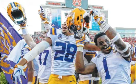  ?? AP PHOTO/BUTCH DILL ?? LSU players celebrate after they defeated Auburn 22-21 on a last-second field goal Saturday in Auburn, Ala.