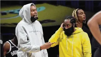  ?? MARK J. TERRILL/ASSOCIATED PRESS ?? Nets forward Kevin Durant (left) and guard James Harden will need to pick up the slack for Kyrie Irving, who the team won’t allow to play or practice until he is vaccinated.