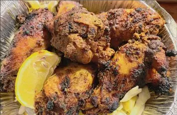  ?? ?? A lightly blackened order of tandoor chicken wings served with shredded cabbage.