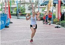  ?? PHOTO BY EMMETT HALL ?? Marlene Persson pumps her arms in the air after winning the women’s division of the Riverwalk Run’s 5K.