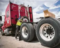  ?? Marie D. De Jesús / Staff file photo ?? Adam Garrett, 59, a trucker who works locally, installs mud flaps on his truck earlier this year at the Port Auto Truck Stop in La Porte. Trucking is among sectors facing a labor shortage.