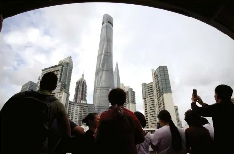  ?? (Aly Song/Reuters) ?? TOURISTS ENJOY a boat tour on the Huangpu River near the financial district of Pudong in Shanghai last week. Chinese travelers, who spent $261 billion overseas last year, are increasing­ly opting for ‘staycation­s,’ a boon for domestic tourism operators,...
