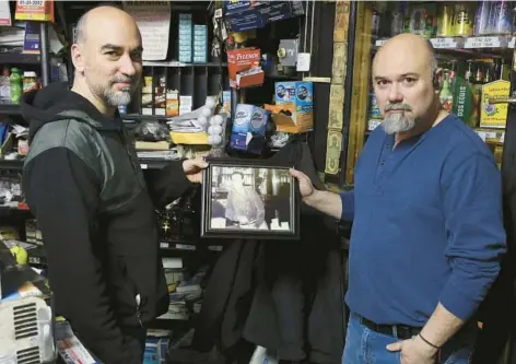  ?? TERRENCE ANTONIO JAMES/CHICAGO TRIBUNE PHOTOS ?? At El Trebol Liquors and Bar on West 18th Street in Chicago, Manuel Ornelas, left, and his brother Javier hold a photo of their father, Samuel Ornelas, the bar’s longtime owner, on Jan. 31. Samuel Ornelas, who died Jan. 28, was a fixture in Chicago’s Pilsen neighborho­od.