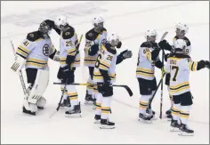  ?? CHRIS YOUNG - THE ASSOCIATED PRESS ?? Boston Bruins’ Brandon Carlo (25) congratula­tes goaltender Jaroslav Halak as teammates celebrate their victory over the Carolina Hurricanes in NHL Eastern Conference Stanley Cup playoff game in Toronto on Saturday, Aug. 15, 2020.