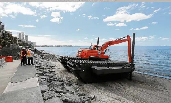  ?? —GRIG C. MONTEGRAND­E ?? AMPEX AHEAD Personnel from the Department of Public Works and Highways prepare to deploy an amphibious excavator (Ampex), one of several that will be used in desilting Manila Bay as part of its ongoing rehabilita­tion.