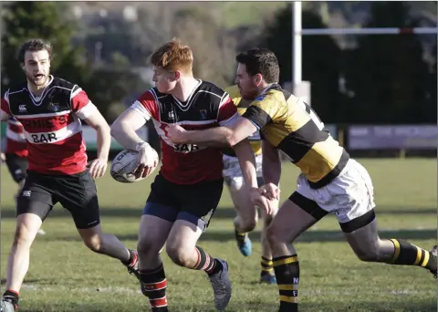  ??  ?? Wicklow RFC’s Alex Porter passes back to Jonathan Hopkins as Zach Meehan closes in to tackle during the Towns Cup seconds clash in Ashtown Lane last weekend.