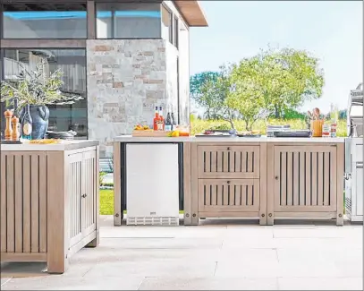  ?? Pottery Barn ?? Planning an outdoor kitchen? The three-piece Abbott modular system from Pottery Barn includes a double-door cabinet, refrigerat­or cabinet and two-drawer plus single-door cabinet with double stainless steel top. It’s crafted from solid acacia wood.