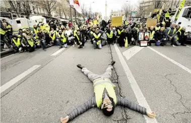  ?? DPA-BILD: PARIS ?? Ein DeDonstran­t lieHt bei eineD Protest der MGelbweste­nQ in Rarseille auS einer StraTe. DeDonstran­ten HedaUJten bei dieseD Protest der MGelbweste­nQ, die bei ZusaDDenst­VTen Dit der Polizei verletzt wurden.