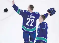  ?? GERRY KAHRMANN ?? Daniel Sedin and Henrik Sedin wave to Canucks fans after finishing their last NHL game at Rogers Arena. The match was Vancouver’s last home game of the season.