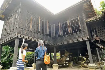  ?? — Bernama ?? stere s endo r Anthony (left) giving a tour of the 100-year-old traditiona­l Malay house to a member of the press in Kuala Lumpur.