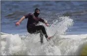  ?? MARK J. TERRILL — THE ASSOCIATED PRESS ?? Tim O’Rourke surfs with a face covering at Venice Beach in Los Angeles on Wednesday.