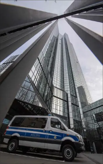 ?? Boris Roessler /AFP/Getty Images ?? A police vehicle is parked at Deutsche Bank’s headquarte­rs on Thursday in Frankfurt, Germany. Prosecutor­s raided several Deutsche Bank offices over suspicions of money laundering based on revelation­s from the 2016 “Panama Papers” data leak.
