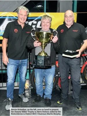  ??  ?? Bernie Schreiber, on the left, was on hand to present the Sammy Miller Trophy to Steve Robson aided by the Kinlochlev­en & District MCC Chairman Martin Murphy.