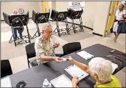  ?? Arkansas Democrat-Gazette/BENJAMIN KRAIN ?? Ken Bushe shows his photo identifica­tion to a poll worker at Laman Library in North Little Rock during a sales tax election in August, the first election after the 2017 voter ID law took effect.